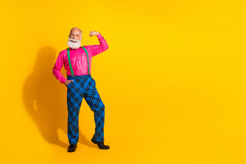 Fototapeta premium Full size photo of handsome pensioner mister flexing muscles wear pink shirt retro plaid pants classy garment isolated on yellow background