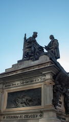 Statue of two kings on a large pedestal in a square of Granada