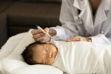 A doctor is examining a baby with a stethoscope. The baby is wrapped in a blanket and he is sleeping. The doctor is checking the baby's heart rate and breathing
