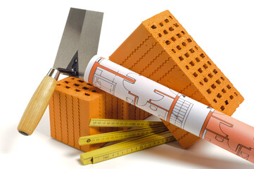  Ziegelsteine und Bauplan liegen zusammen für Hausbau und Wohnungsbau - Symbolbild
