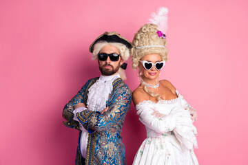 Couple in Historical Costumes Posing Against a Pink Background in Aristocratic Style