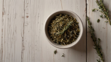 Fototapeta premium Bowl with dried thyme on white wooden table, top view. Space for text