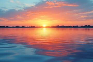 Naklejka premium Vibrant sunset over tranquil waters reflecting a colorful sky at a serene lakeside in the early evening