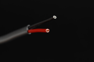 Grey stripped electrical wire on black background, closeup