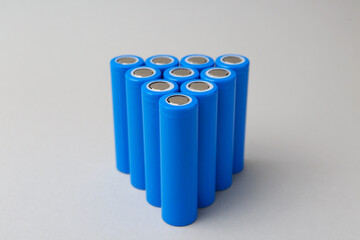Many AA cell batteries on light grey background, closeup