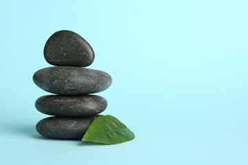 Stack of rocks on light blue background, space for text. Harmony and life balance