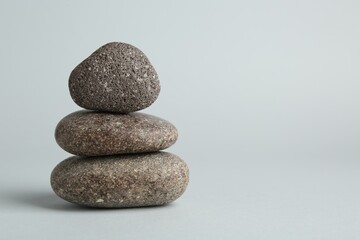 Stack of rocks on light grey background, space for text. Harmony and life balance