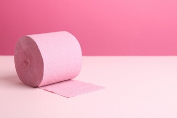 Color toilet paper roll on pink background. Space for text