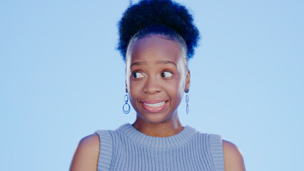 Guilt, embarrassed and awkward with a black woman in studio on a blue background feeling nervous. Thinking, idea and worried with a young feeling looking insecure or anxious about a mistake