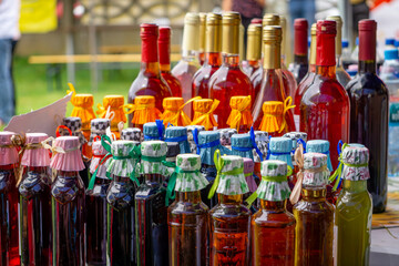 juices, liqueurs, home-made wines lying on the village table at the festival
