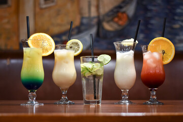 Summer coctails in the table. Piña Colada with pineapple slice, Blue lagoon, mojito with lime and...