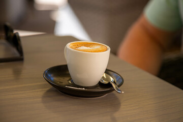 Eine Tasse professionell zubereiteter Milchkaffee auf einem Tisch in einem Cafe