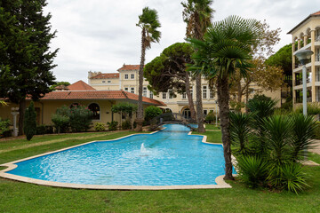 Pool mit Palmen in einer Ferienanlage