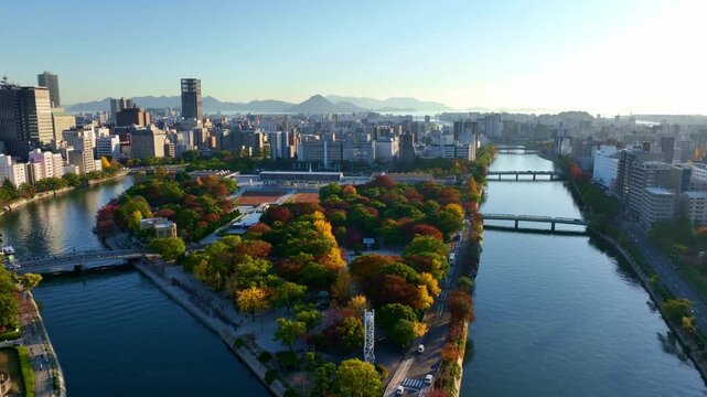 flying above downtown Hiroshima, aerial view of Hiroshima Peace park, establishing shot of Motoyasu river in Hiroshima, travel in Japanese city of Hiroshima
