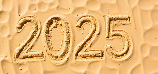 "2025" text written in beach sand - new year concept for calendars, planners, and holiday marketing materials