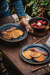 Comida cocinada en platos y sartenes de metal al exterior en un campamento de día