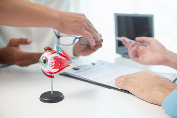 ophthalmologist is examining the patient's eye abnormalities to correct them so that they can see...