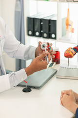 ophthalmologist is examining the patient's eye abnormalities to correct them so that they can see...