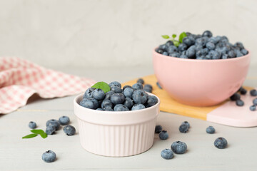 Bowl with fresh bright blueberries on wooden table