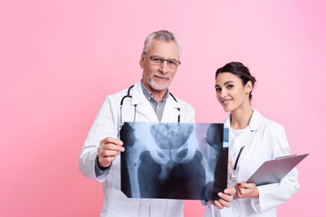 Portrait of male and female doctors with stethoscopes holding x-ray and clipboard isolated.