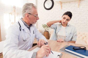 Doctor with stethoscope and female patient in office. Doctor is using tablet.
