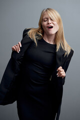Fototapeta premium Confident Woman Posing in Black Outfit Expressing Joyful Emotion..