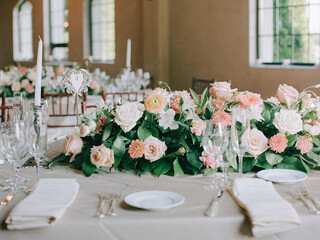 Elegant wedding table setting adorned with lush floral arrangements in a bright reception hall