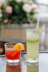 Refreshing cocktails served at an outdoor gathering with vibrant floral background during the evening hours