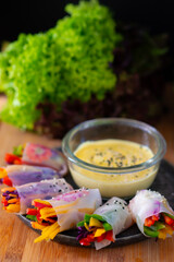 Vegetarian vietnamese spring rolls with spicy sauce, carrot, cucumber, red cabbage. Vegan food. Tasty meal. Copy space
