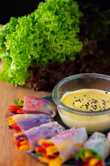 Vegetarian vietnamese spring rolls with spicy sauce, carrot, cucumber, red cabbage. Vegan food....