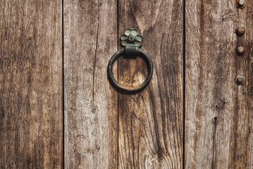 Metal gong on an old wooden door.