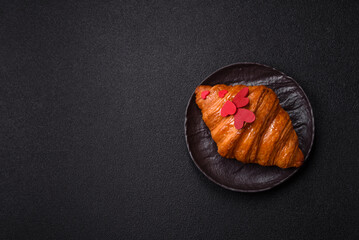 Sweet crispy croissant decorated with red hearts