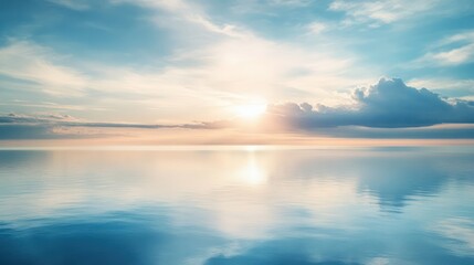 The sun is rising over calm water and blue sky
