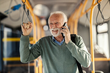 Portrait of a smiling old passenger commuting by public city bus and having phone call. © Dusan Petkovic