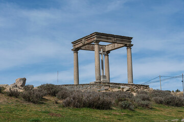Fototapeta premium The Mirador Los Cuatro Postes or the Four Posts, an ancient monument viewpoint over the Spanish fortified walled city of Ávila marks the city limits