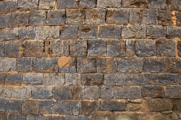 Rustic stone wall with irregular brown rocks and white mortar, creating a textured architectural background.