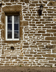 Fototapeta premium Rustic stone wall with irregular brown rocks and white mortar, creating a textured architectural background.
