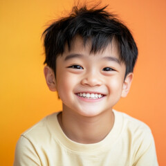 A smiling Asian boy, exuding joy, set against a colorful plain background, captured in a commercial photography style, perfect for advertising and marketing campaigns