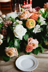Elegant floral centerpiece at a dining table set for a celebratory event in a cozy indoor venue