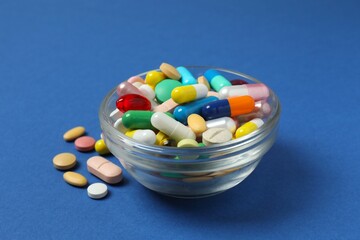 Various pills in a bowl on a color background