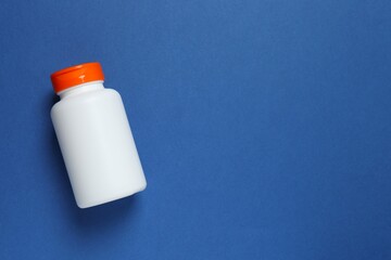 White bottle on blue background, top view