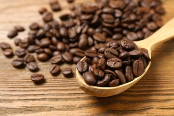 Fresh coffee beans in a spoon on wooden background