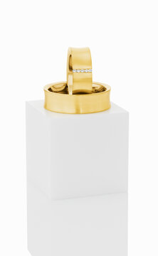 Wedding rings on top of white pedestal.