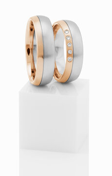 Wedding rings on top of white pedestal.