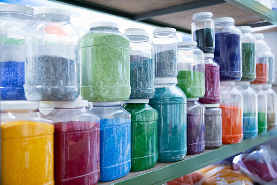 Color grains of plastic in containers used for high pressure plastic molding.
