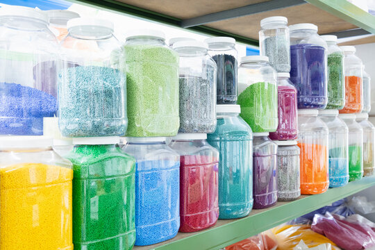 Color grains of plastic in containers used for high pressure plastic molding.