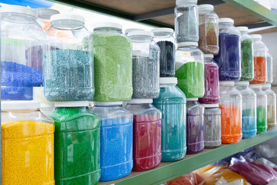 Color grains of plastic in containers used for high pressure plastic molding.