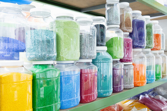Color grains of plastic in containers used for high pressure plastic molding.
