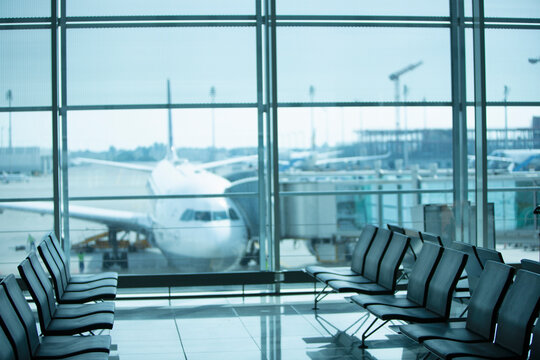 Row of seats at an airport with airplane in the background
