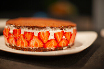 Chocolate topped strawberry cake in a kitchen.